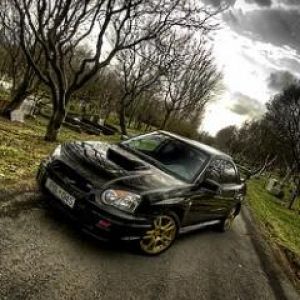 Carro esportivo preto em uma estrada cênica