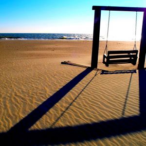 Balançoire na praia ao pôr do sol