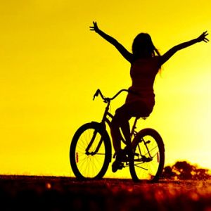 Menina Andando de Bicicleta ao Pôr do Sol