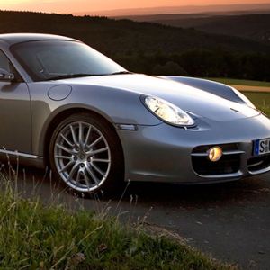Carro esportivo prateado ao pôr do sol